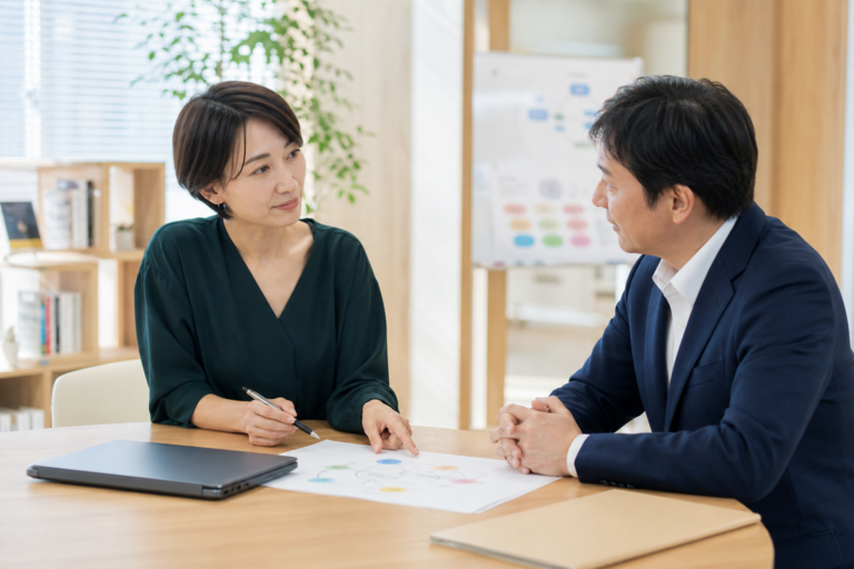 介護事業所でケアマネジャーと採用担当者がケアプランと採用条件を確認する様子